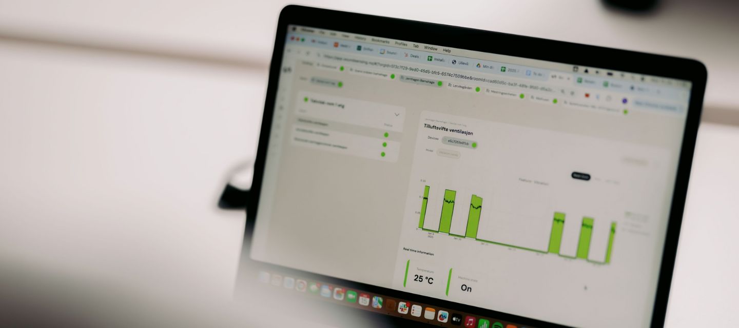 Predictive‑maintenance dashboard van VINCI Facilities op een laptop, met grafieken voor systeemstatus en energie‑optimalisatie