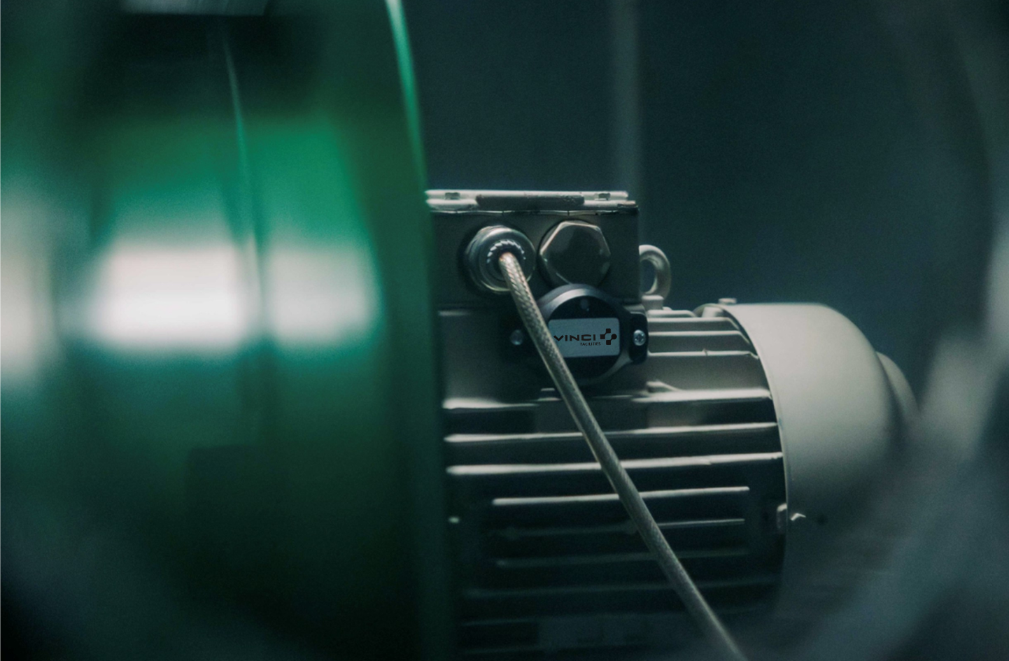 Vibration sensor for predictive maintenance installed on an industrial motor.