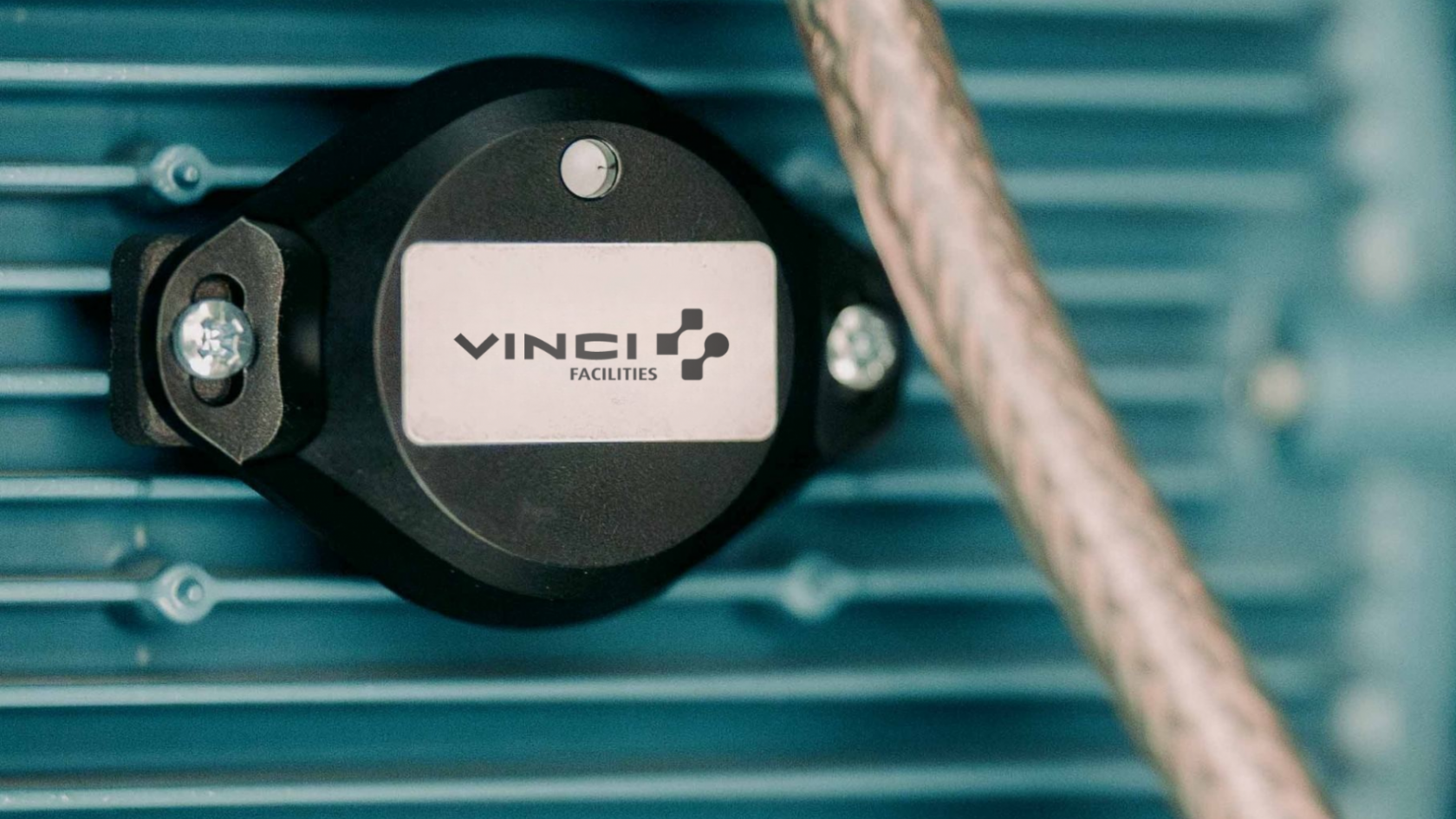 Vibration sensor for predictive maintenance installed on an industrial motor.